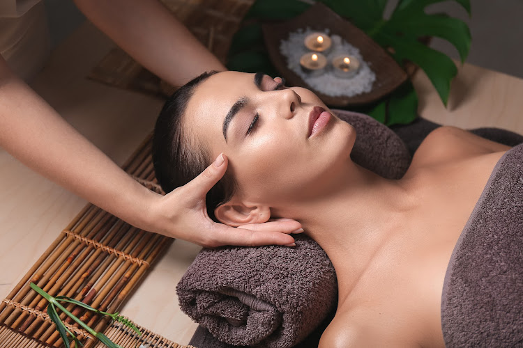 Beautiful young woman receiving massage in spa salon